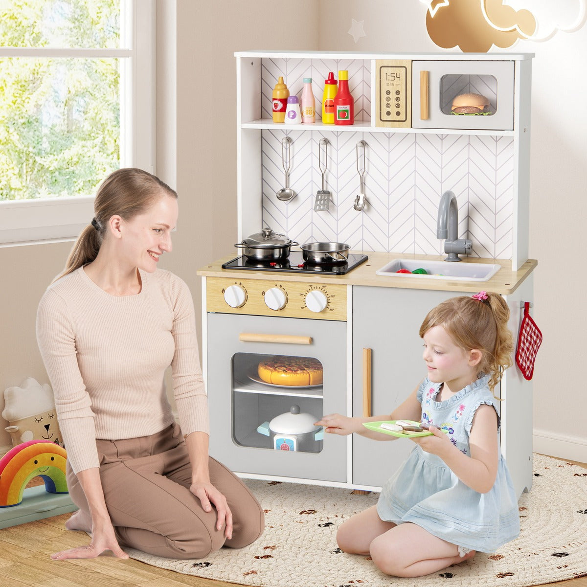 Mother and daughter playing with the kitchen playset