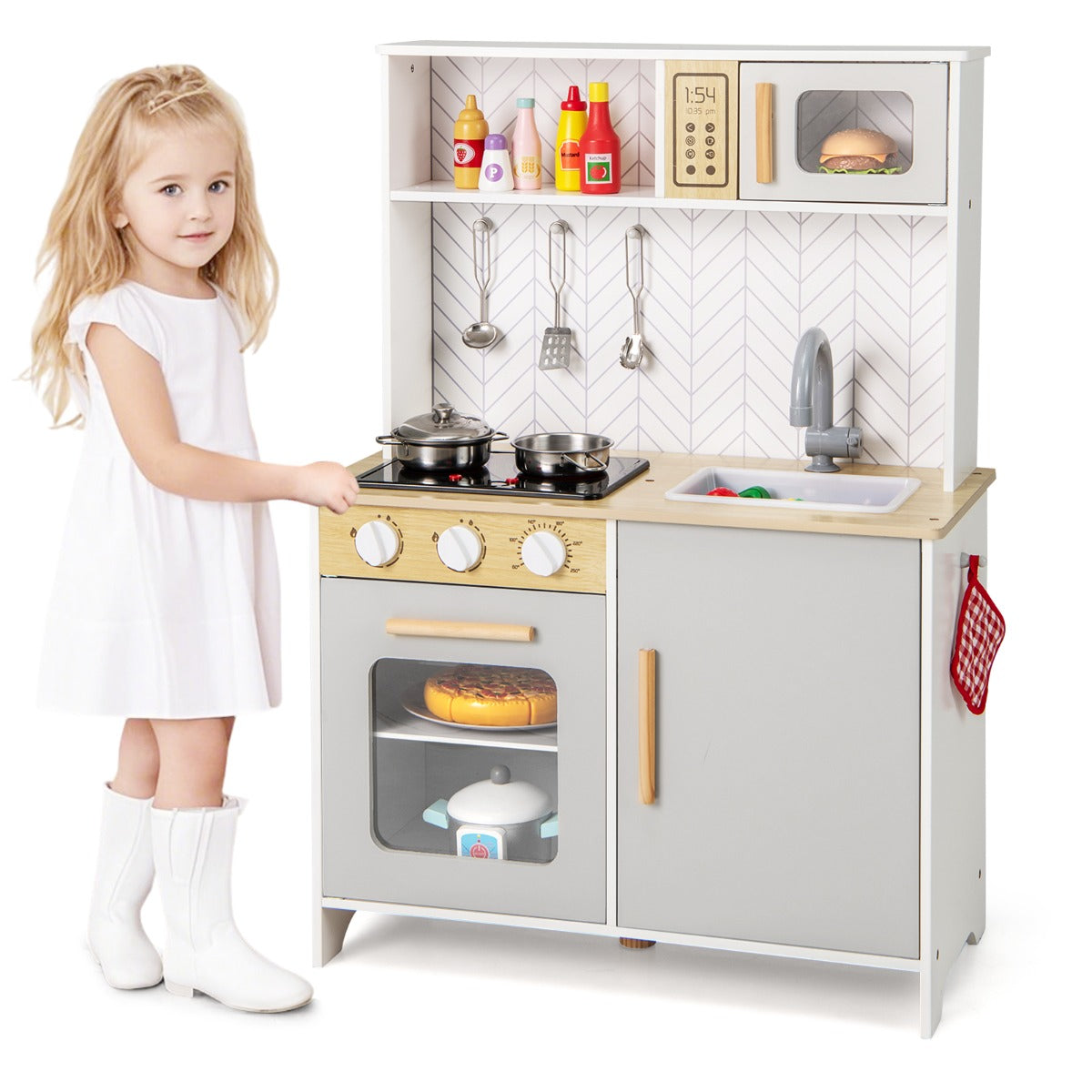 Young girl standing by the white kitchen playset