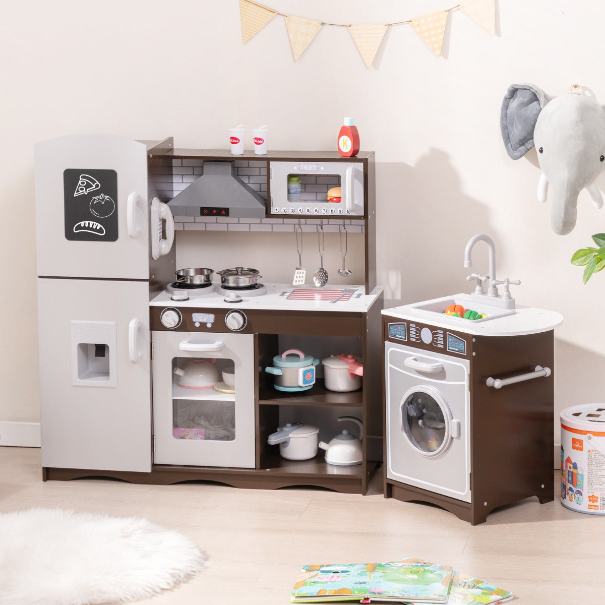 The play kitchen set with fridge, oven, hob, microwave and washing machine in a room with decorations