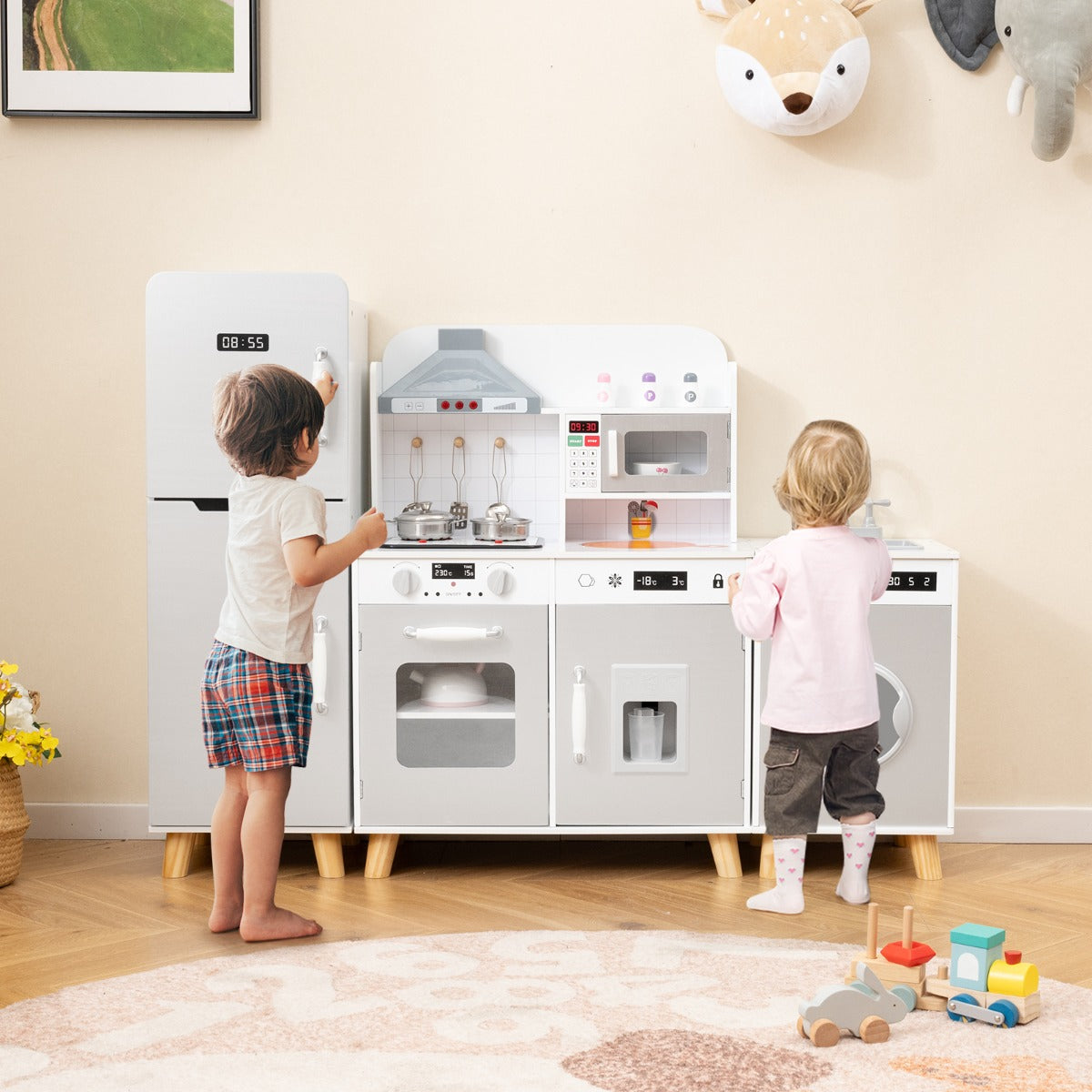 Two children playing with the grey kitchen playset with refrigerator and washing machine