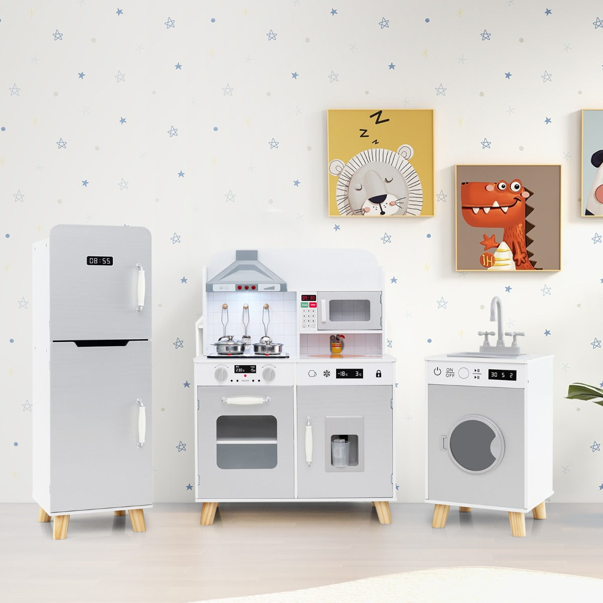 The grey play kitchen set with refrigerator and washing machine displayed in a room with wall art