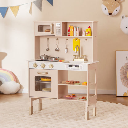 The pink play kitchen set is shown in a child's bedroom with toys