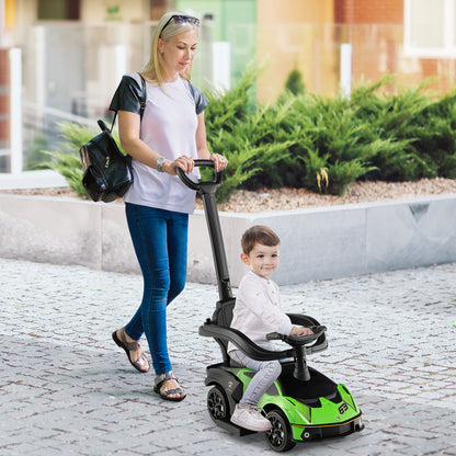 A woman pushes a young boy in the green ride on car along a pavement