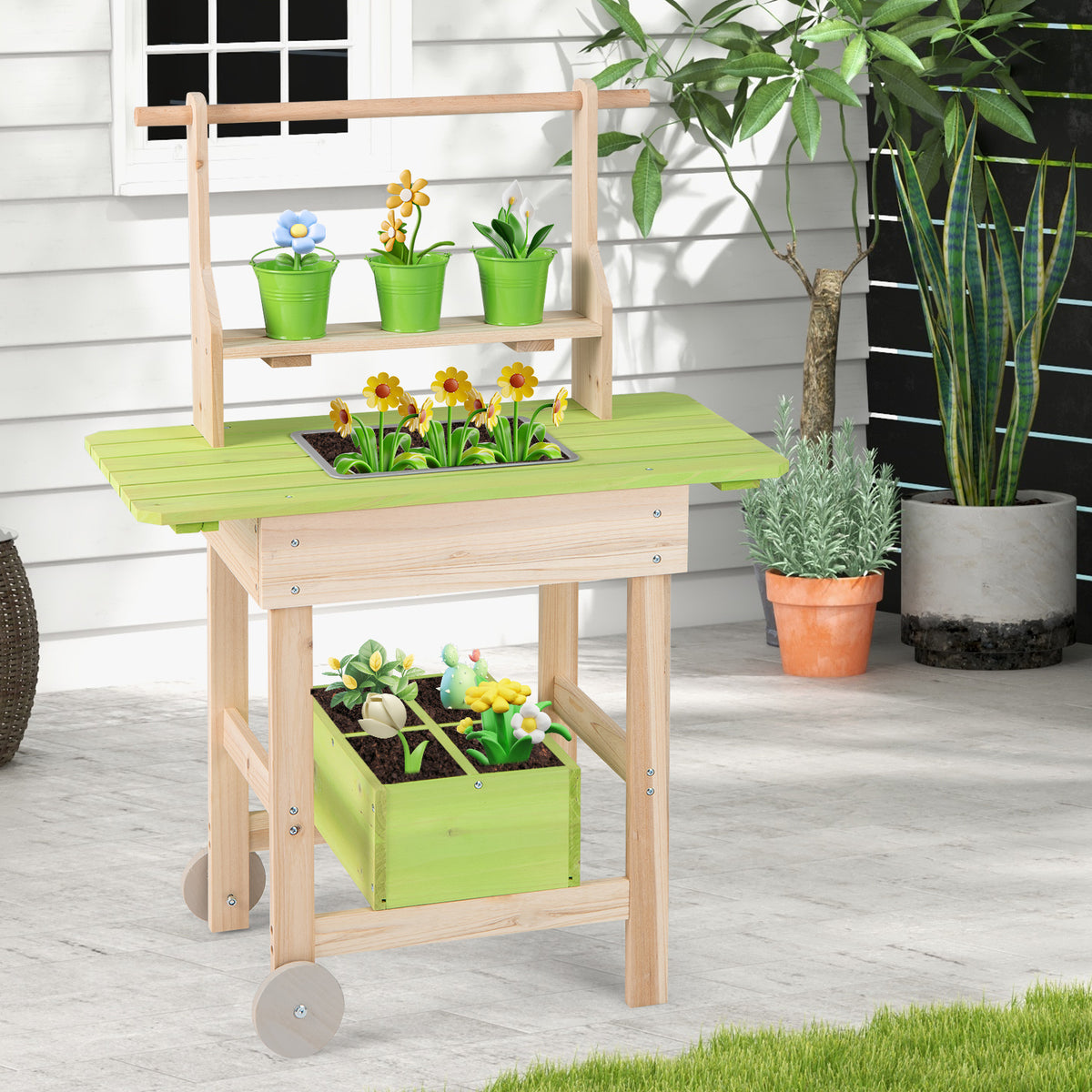 The wooden play kitchen placed on a light grey stone floor against a white wall with plants