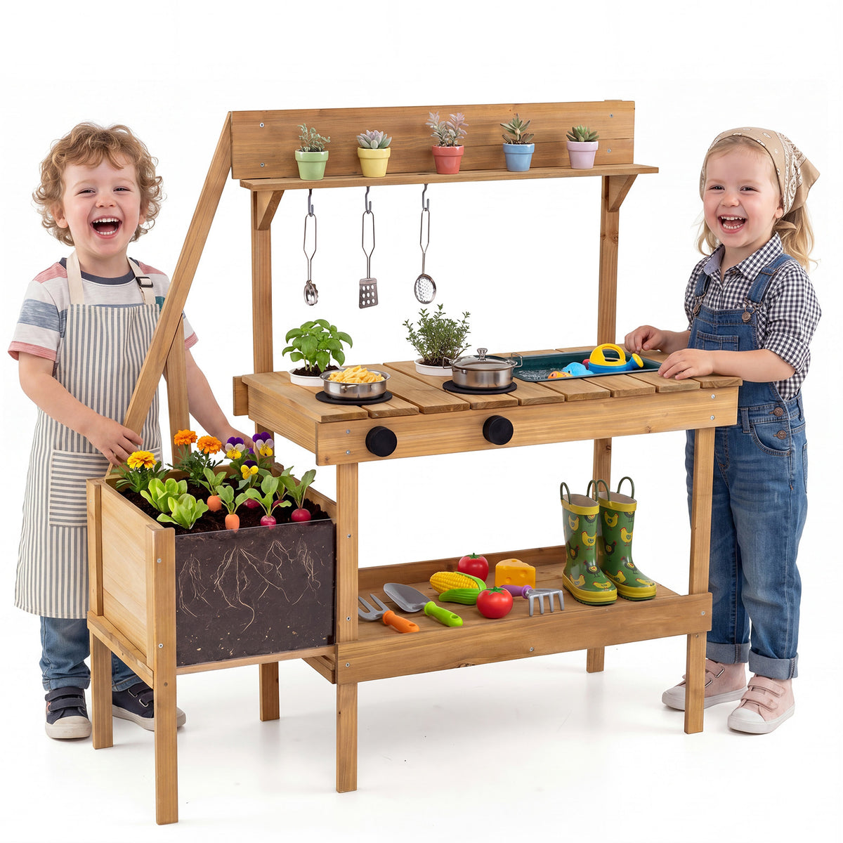 Two happy children stand by the wooden play kitchen set in a garden