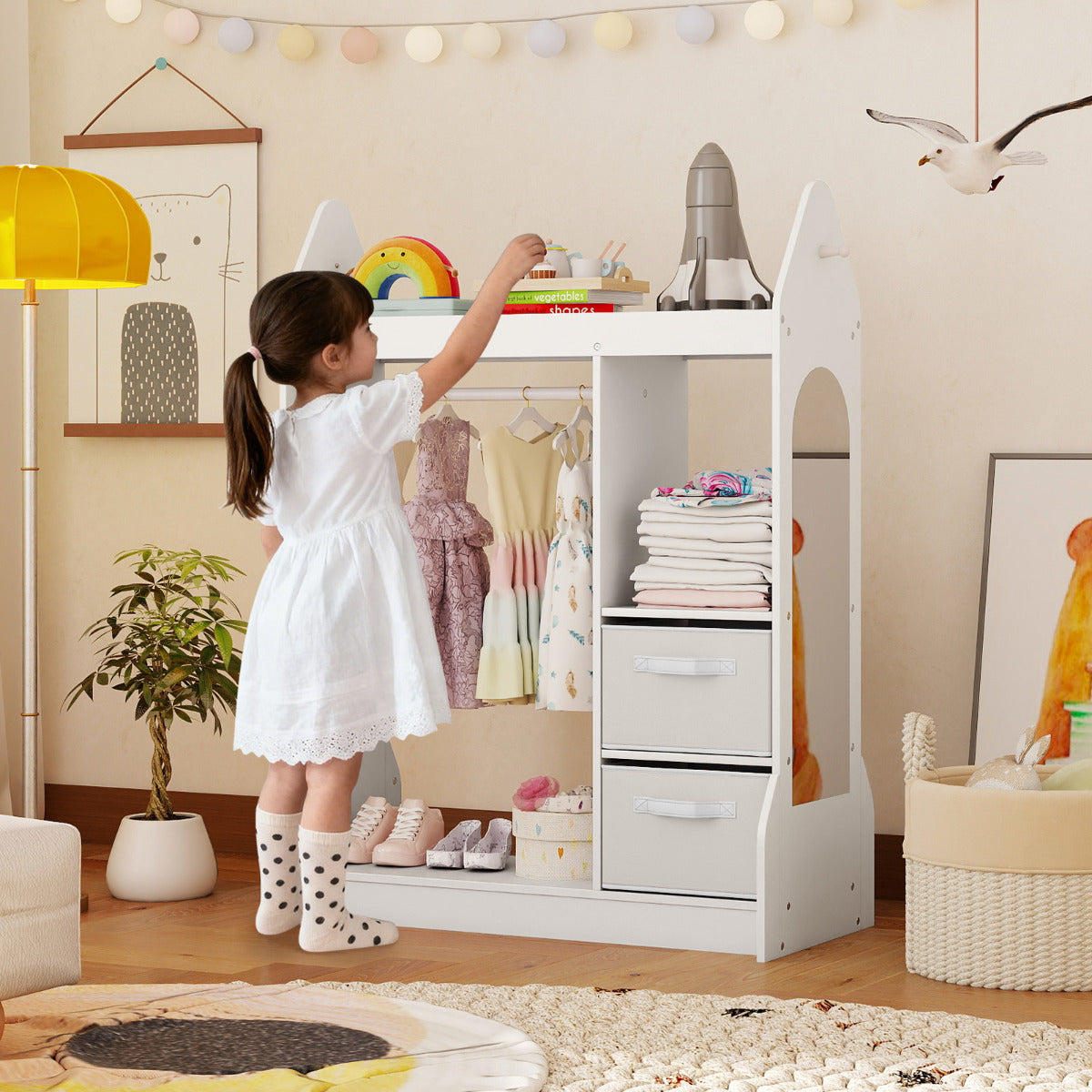 A young girl using the white kids play armoire dresser with mirror