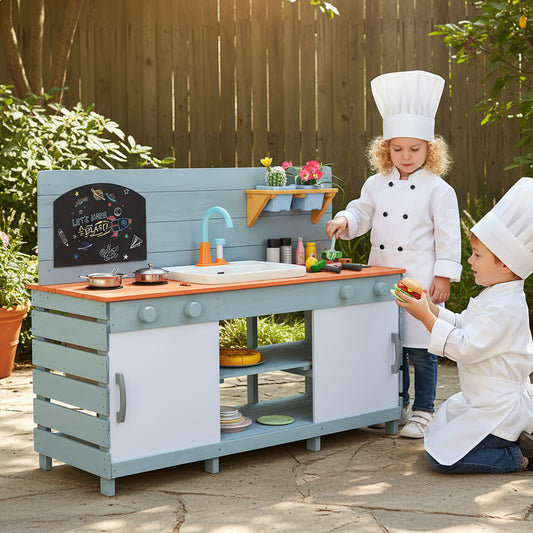 The play kitchen set being used by two children in chef outfits in a garden