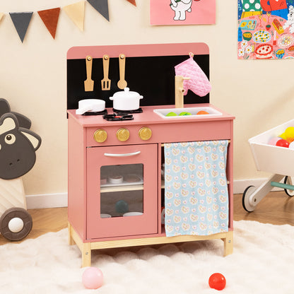 Pink play kitchen set with accessories in a room with toys