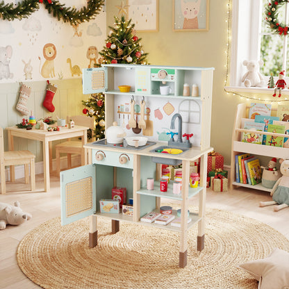 The green play kitchen set is shown in a festive room with a Christmas tree and presents