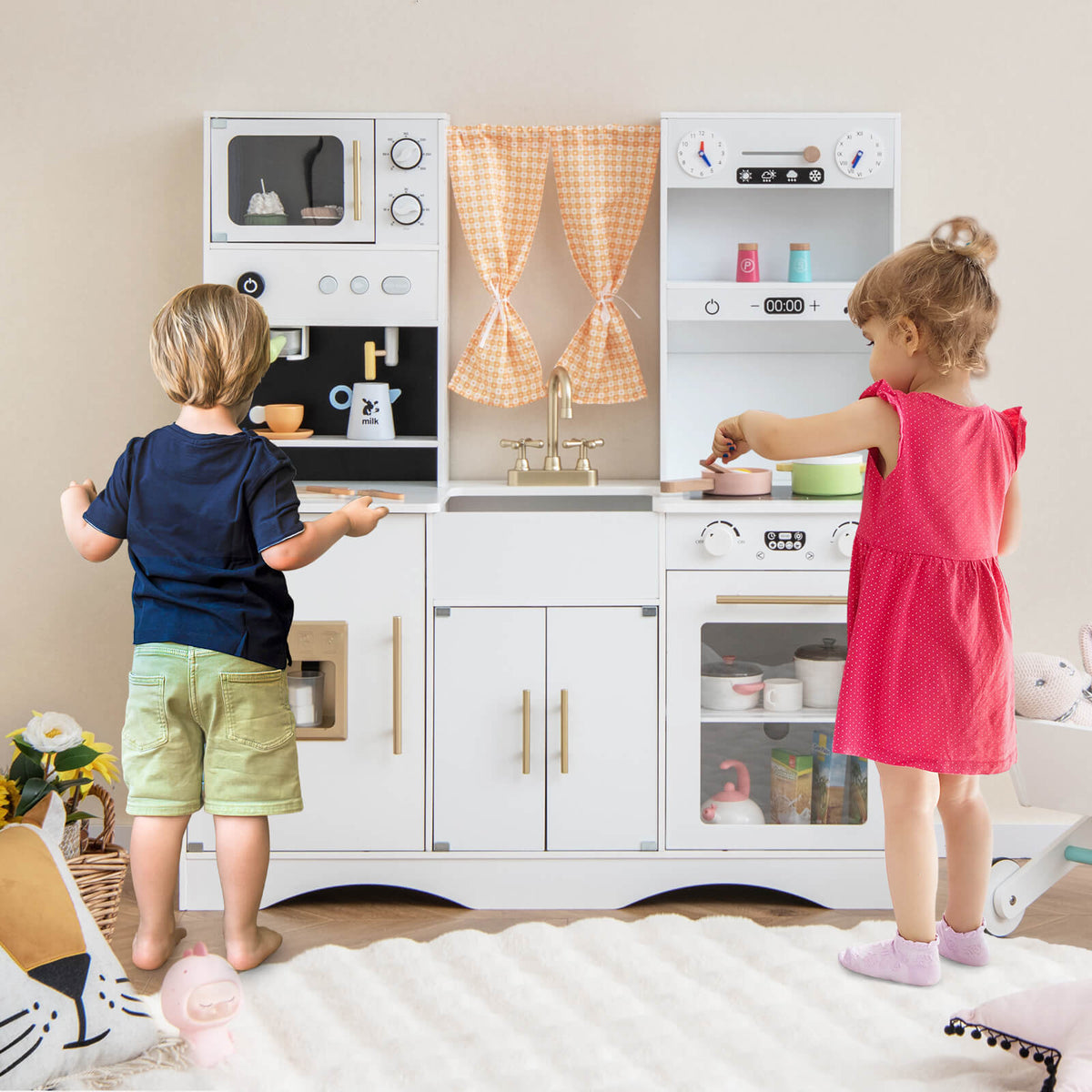 Children playing with the wooden play kitchen set, one child at the stove and another at the sink
