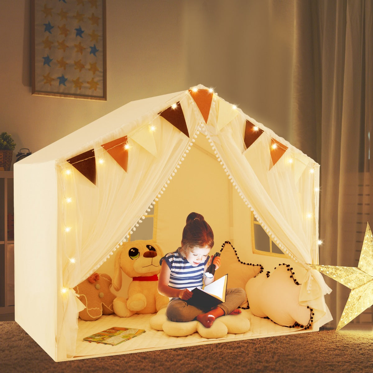 a child reading a book inside the beige play tent house with fairy lights