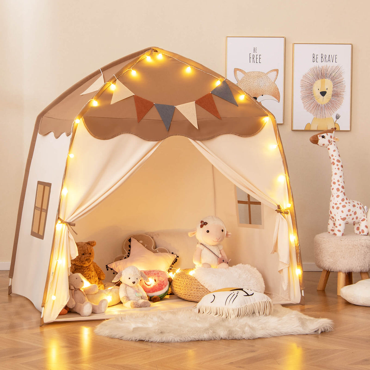 The play tent with fairy lights and bunting, decorated with stuffed animals and cushions