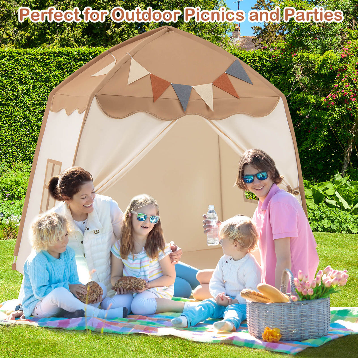 The play tent set up outdoors on grass with a family enjoying a picnic