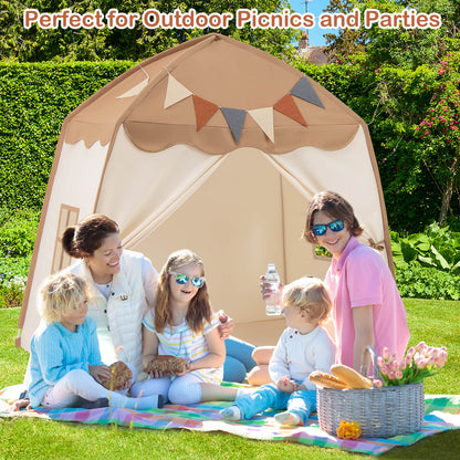 The play tent set up outdoors on grass with a family enjoying a picnic