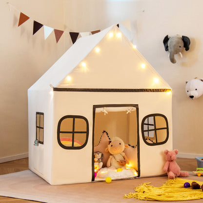 The play tent decorated with fairy lights and bunting in a bright playroom setting