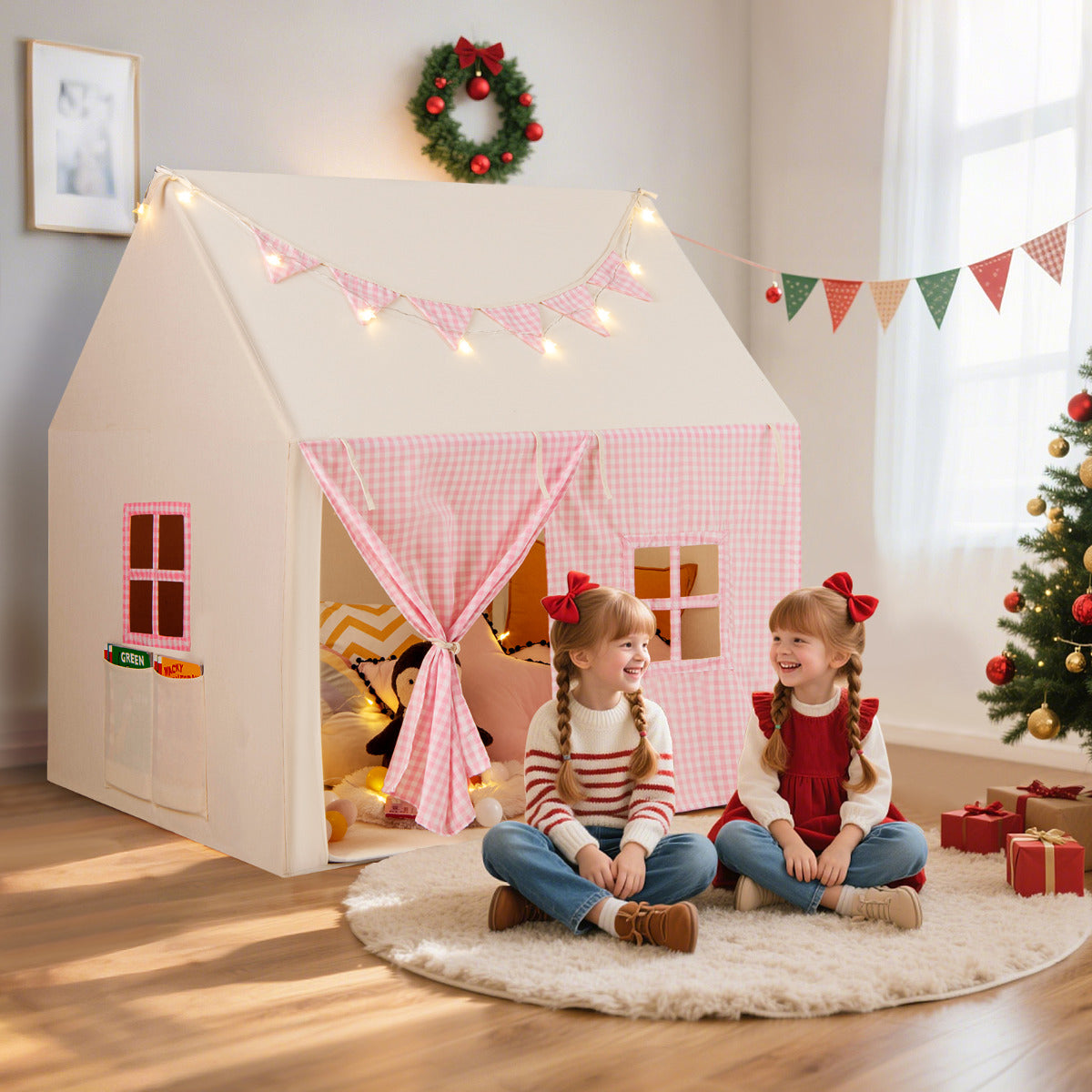 The pink play tent set up indoors with a padded mat and fairy lights on the roof