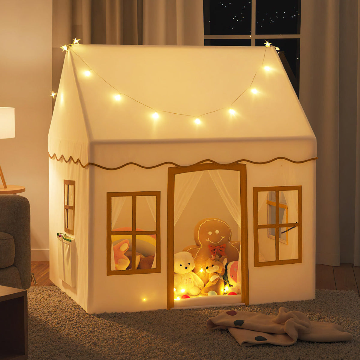 The play tent is lit up at night with soft interior lighting and fairy lights