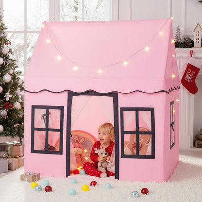 The play tent set up in a festive living room with a child sitting inside with soft toys