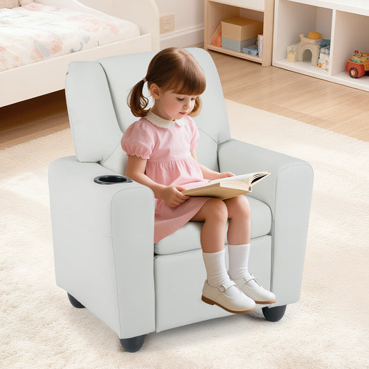 A young girl sitting on the beige kids chair reading a book in a bright bedroom