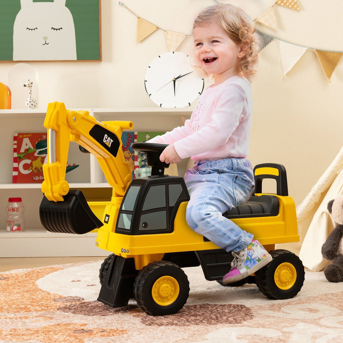 A young girl sitting on the yellow ride on toy inside a child's bedroom