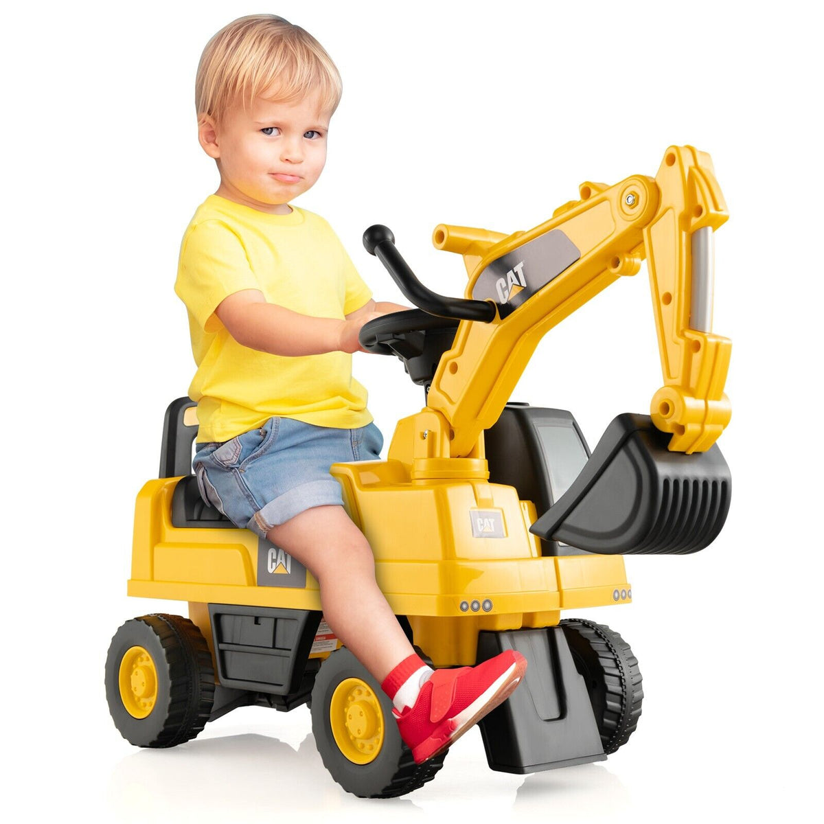 A young boy sitting on the yellow ride on toy against a plain white background