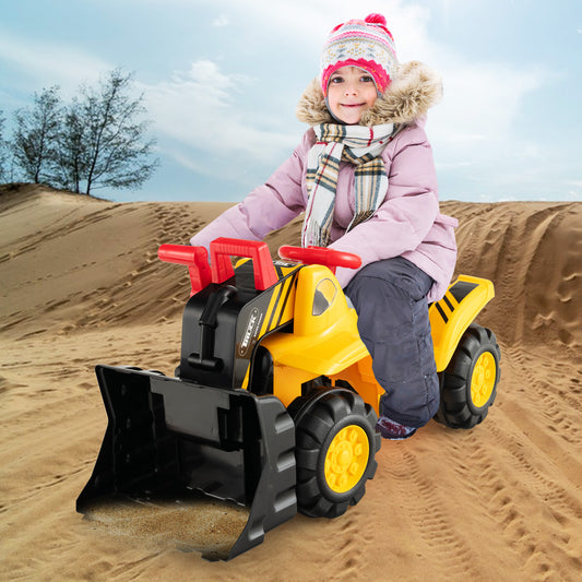 The ride on toy being used by a child in winter clothes on a sandy beach