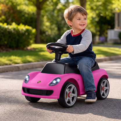 A happy child sitting on the pink sliding car while playing on a sunny street