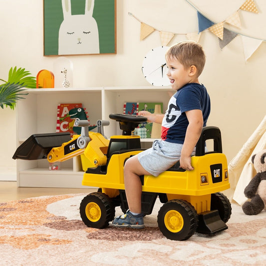 A young boy sitting on the yellow ride on toy in a bright playroom with a white shelf behind