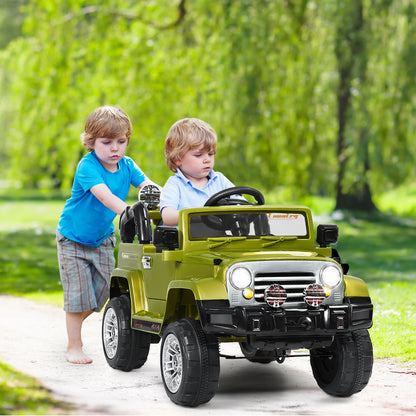 A green kids ride on jeep car with two boys, one pushing and one sitting in the driver's seat