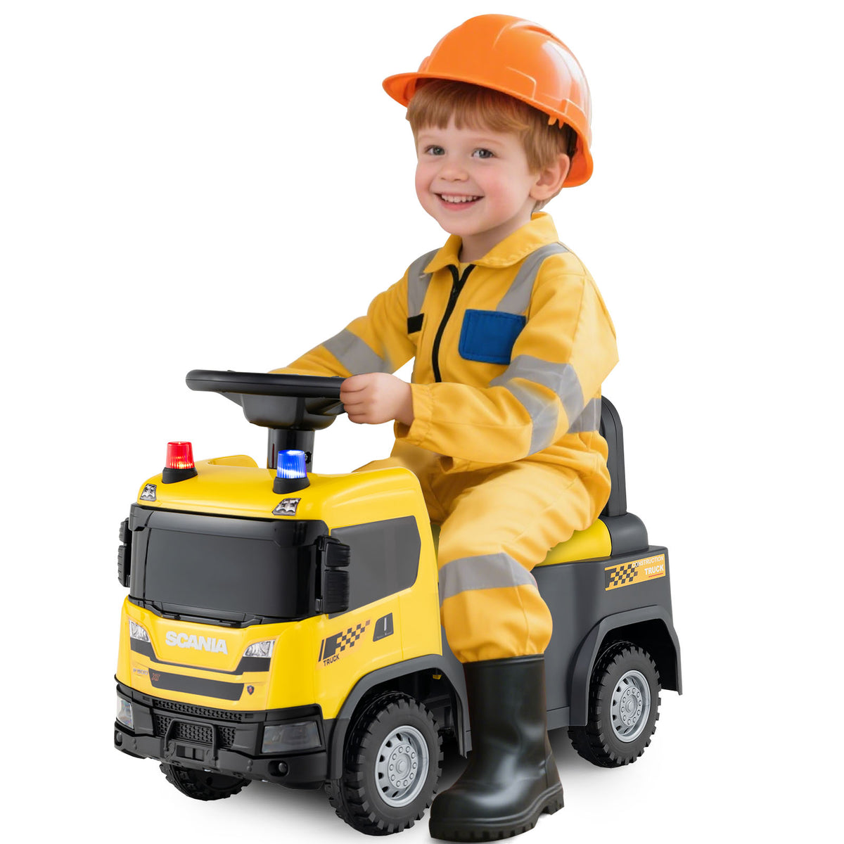 A happy boy in an orange helmet and yellow outfit sits on the yellow push car