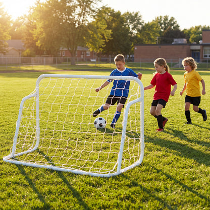 Children playing football on a grassy field with a white metal goal