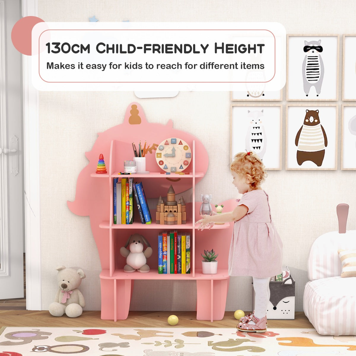 A young child reaching for a book on the pink unicorn storage unit