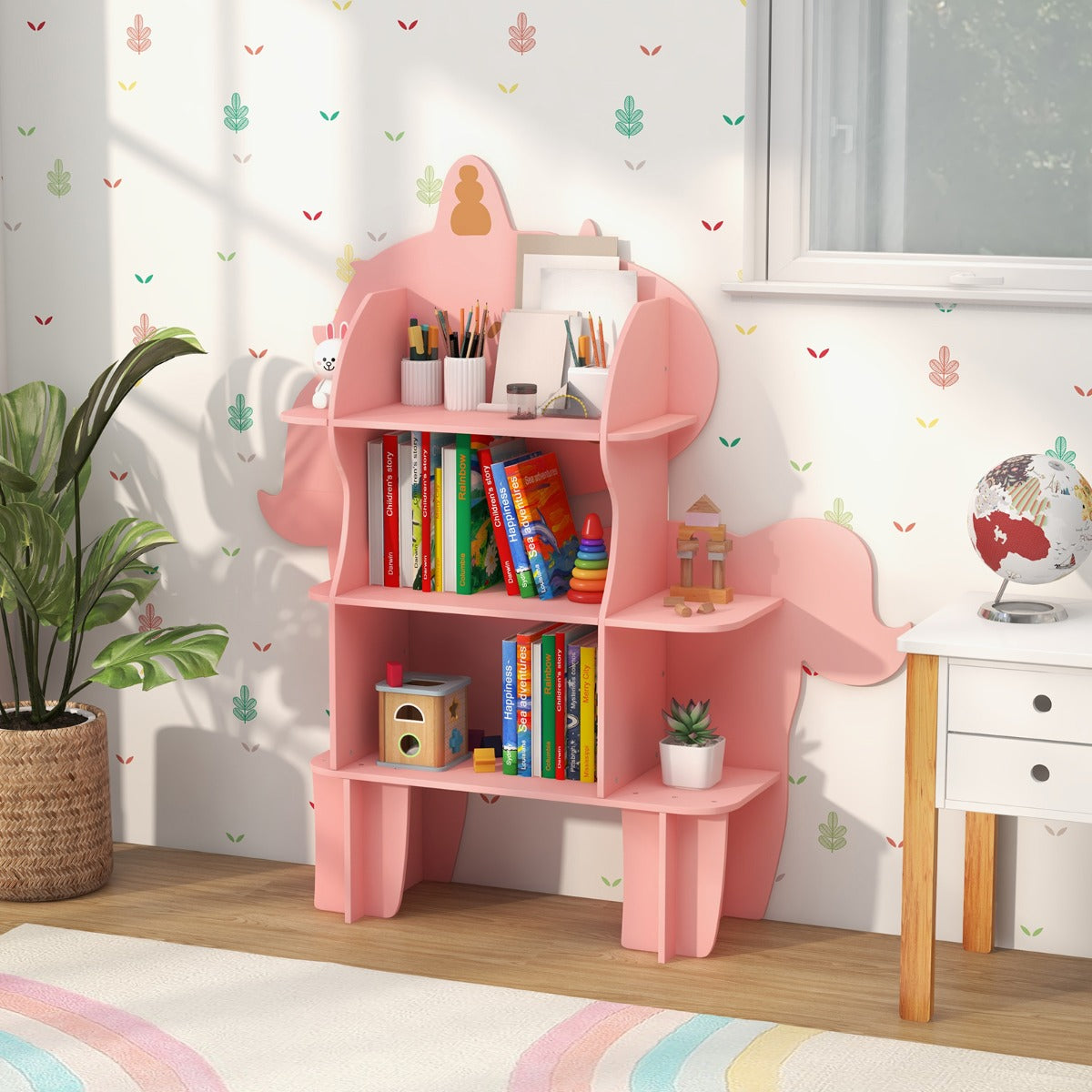 The unicorn toy storage unit displaying books, art supplies and a globe