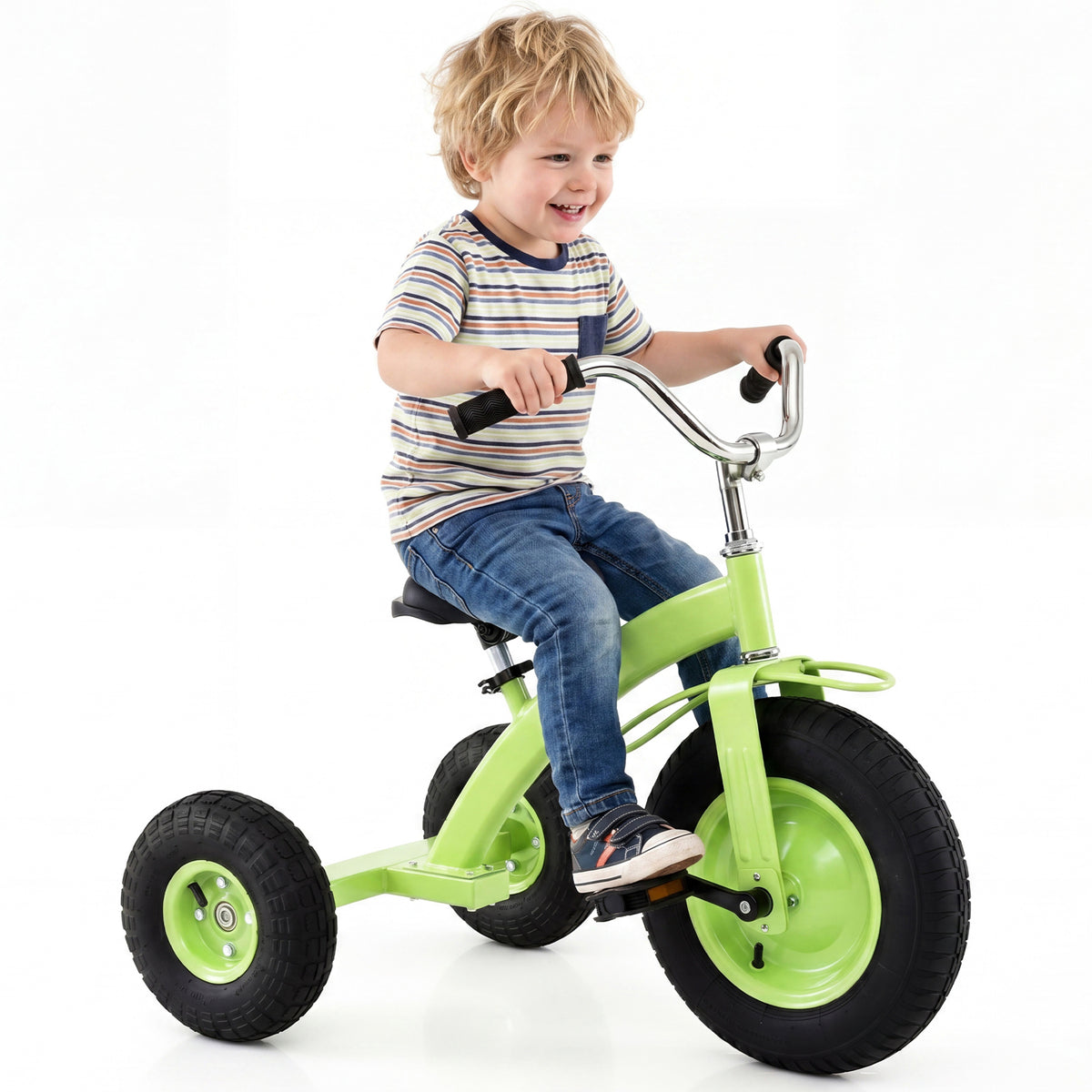A young boy smiles while riding a green kids tricycle