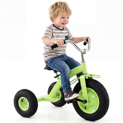 A young boy smiles while riding a green kids tricycle