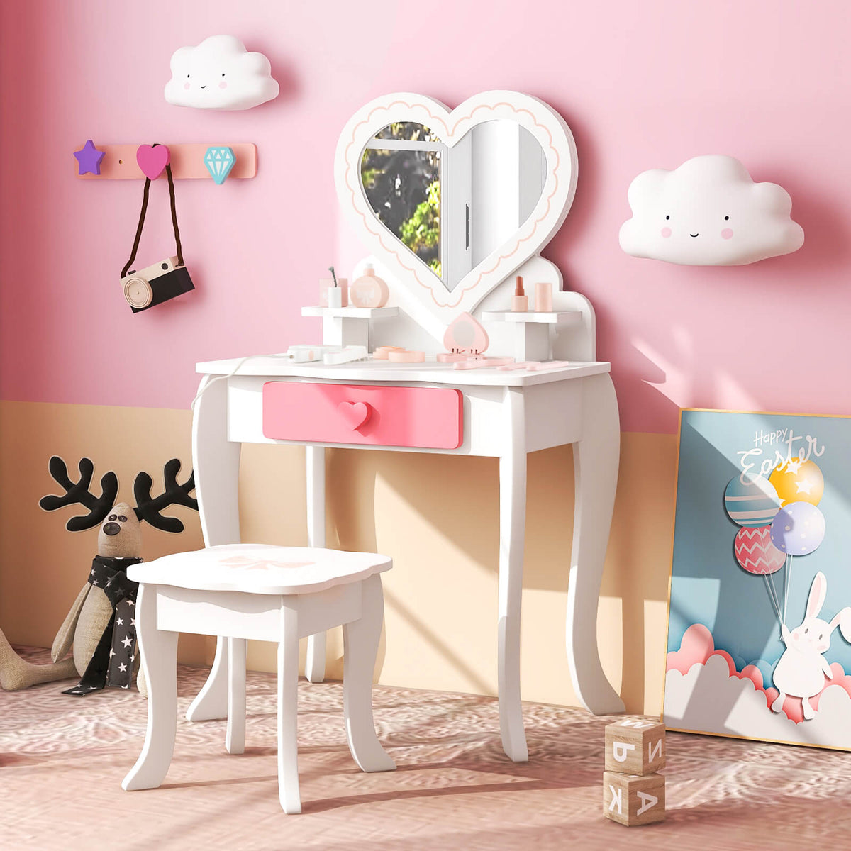 The kids vanity table and stool set in a child's bedroom with pink walls and soft toys