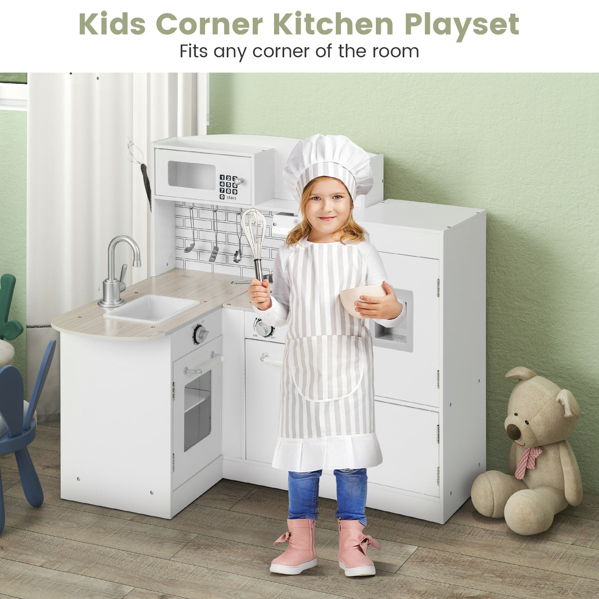 A girl in a chef's outfit stands next to the wooden corner play kitchen in a room