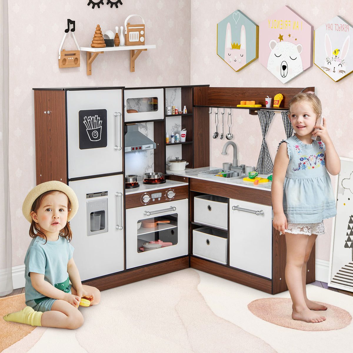 The play kitchen set in a child's bedroom with two young children playing with the accessories