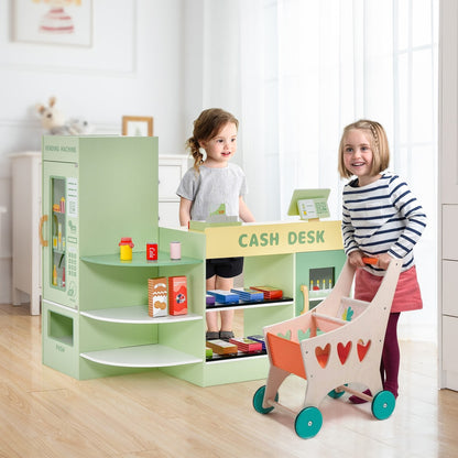 Children playing with a wooden grocery store and shopping trolley