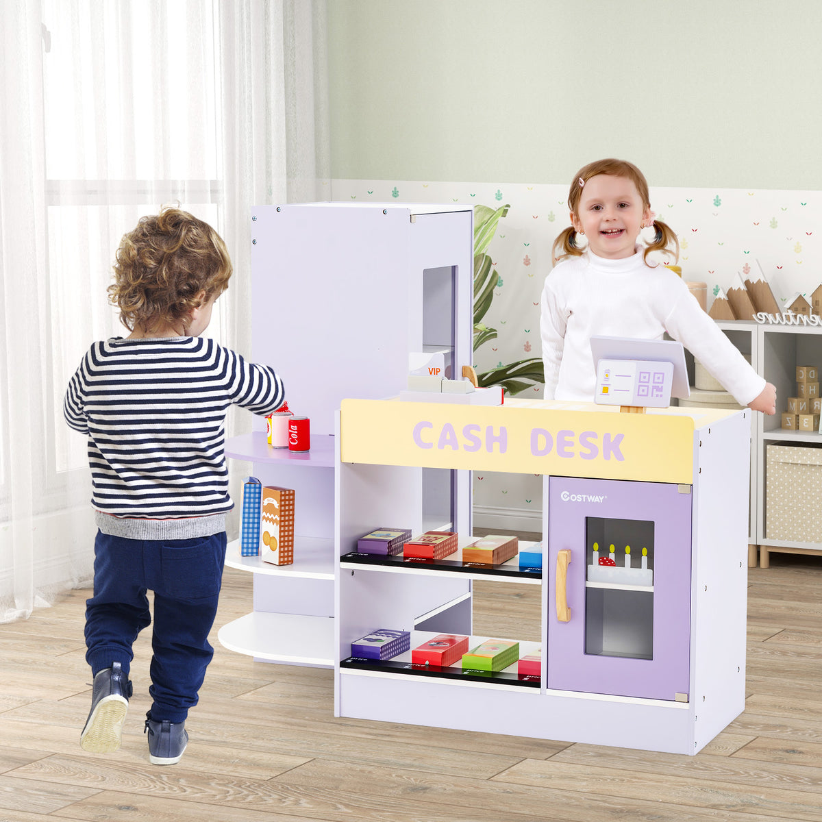Children playing at the purple wooden grocery store play set, interacting with the cash desk