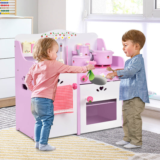 Two young children playing together with the pink wooden play kitchen set in a bright room