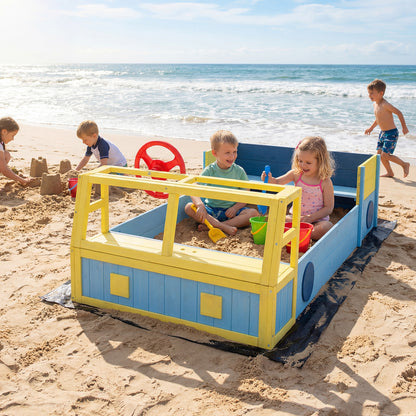 The wooden sand pit set up on a sandy beach with children playing near the ocean