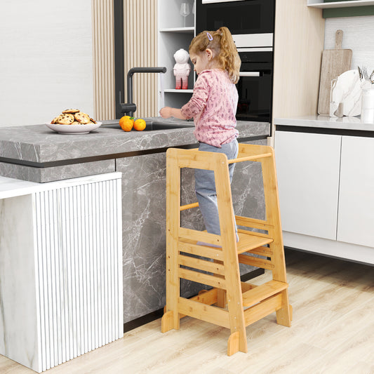 Toddler standing at a kitchen counter using the wooden step stool