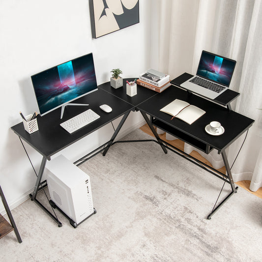 The office desk set up in a corner with a computer, laptop and stationery on the surface