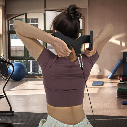 Woman performing a triceps pushdown exercise with a curved bar attachment