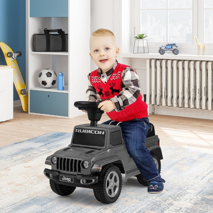 Boy sitting on the grey Jeep ride on push car in a room