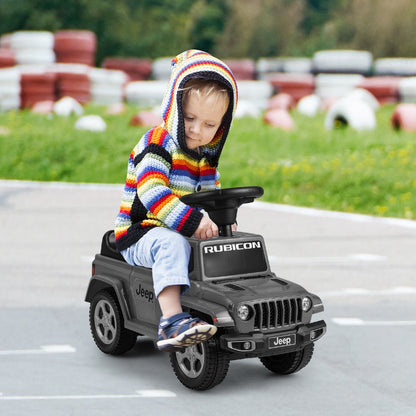 Toddler sitting on the grey Jeep ride on push car outdoors