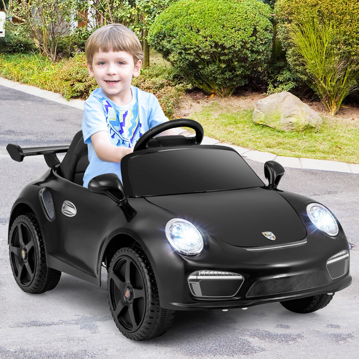 Black kids electric car with a child driving it outside on a paved area