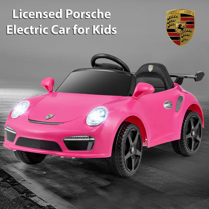 Rose pink electric car with Porsche badge and lights on, studio shot