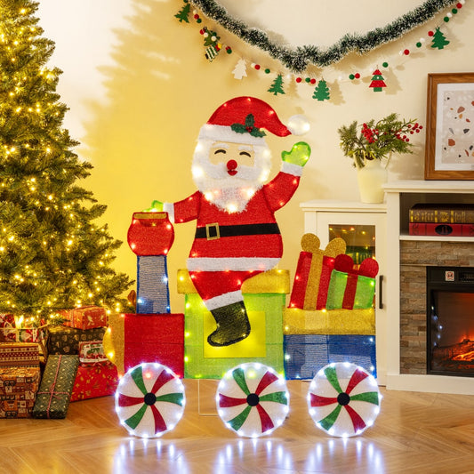 The lighted Santa on train decoration is shown indoors with a Christmas tree and presents